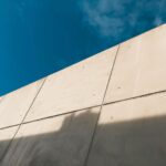 Minimalistyczna ściana z betonu architektonicznego na tle błękitnego nieba