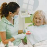 Dentysta omawia z seniorem higienę jamy ustnej i użytkowanie protezy