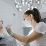 Dentystka leczy zęby pacjentce w nowoczesnym, jasno oświetlonym gabinecie