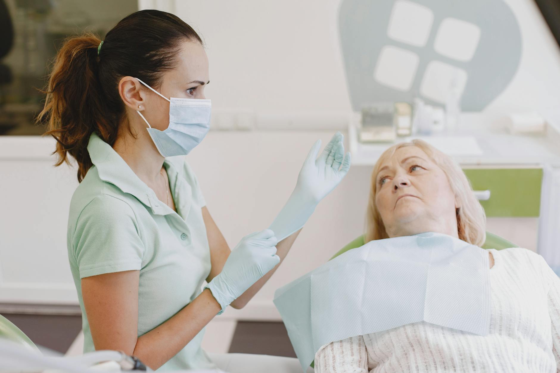 Dentystka przygotowuje starszą pacjentkę do badania protetycznego