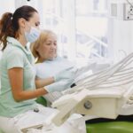 Dentystka rozmawia z starszą pacjentką o protezie w nowoczesnym gabinecie